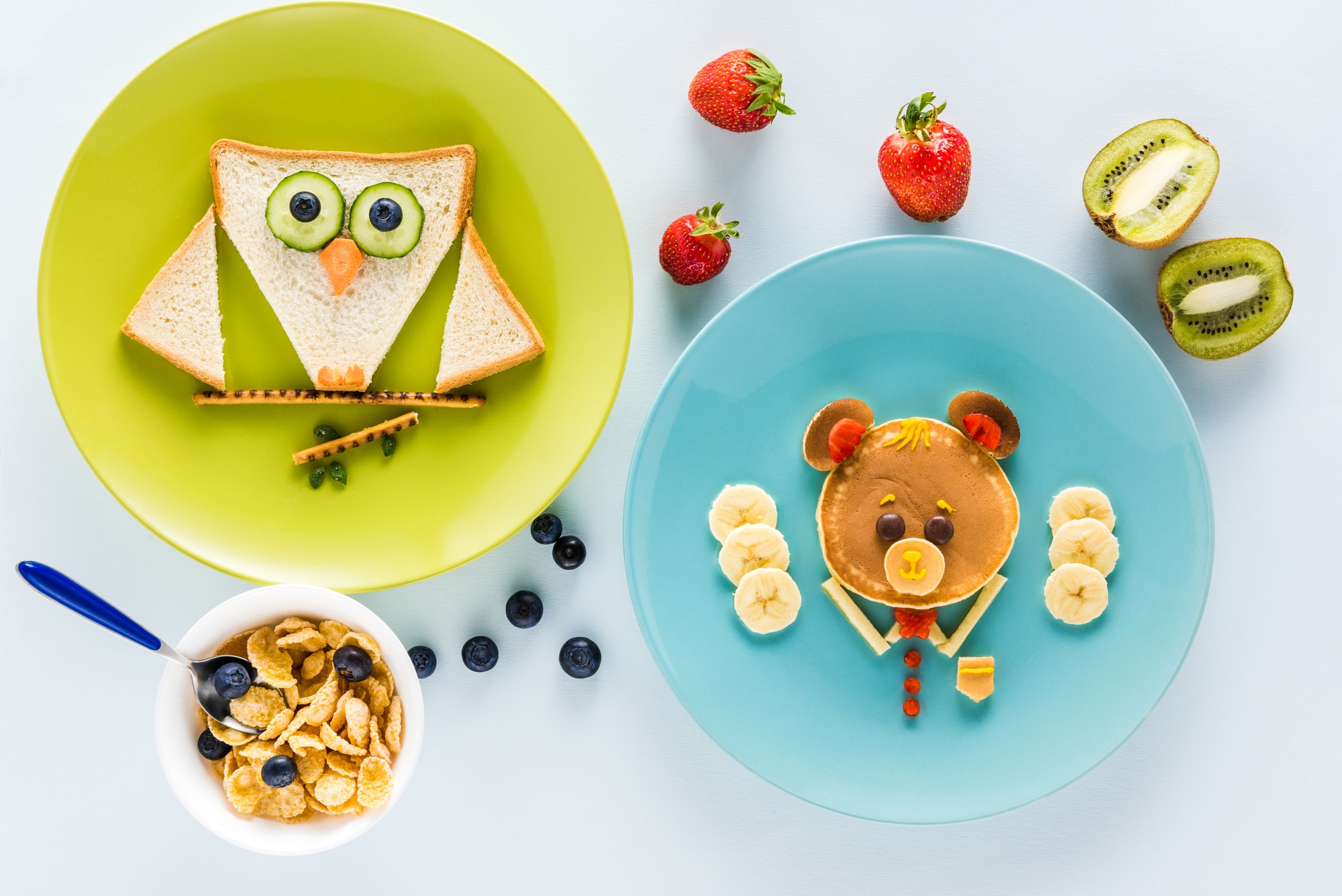 flat lay with creatively styled children's breakfast with berries and kiwi