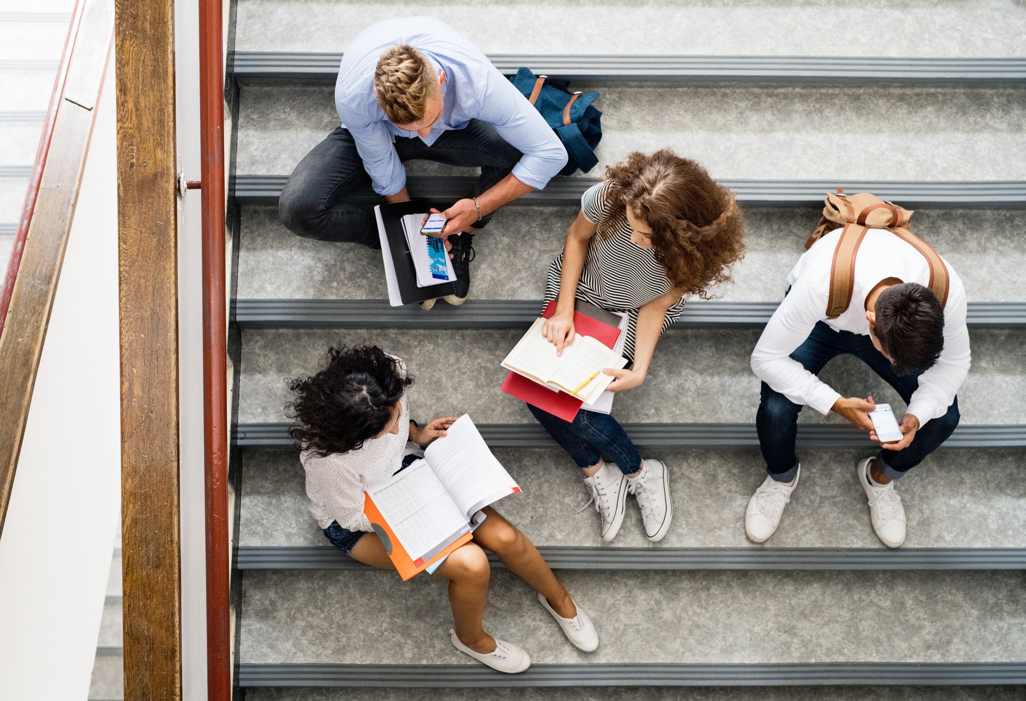 Teenage students on stairs in high school.