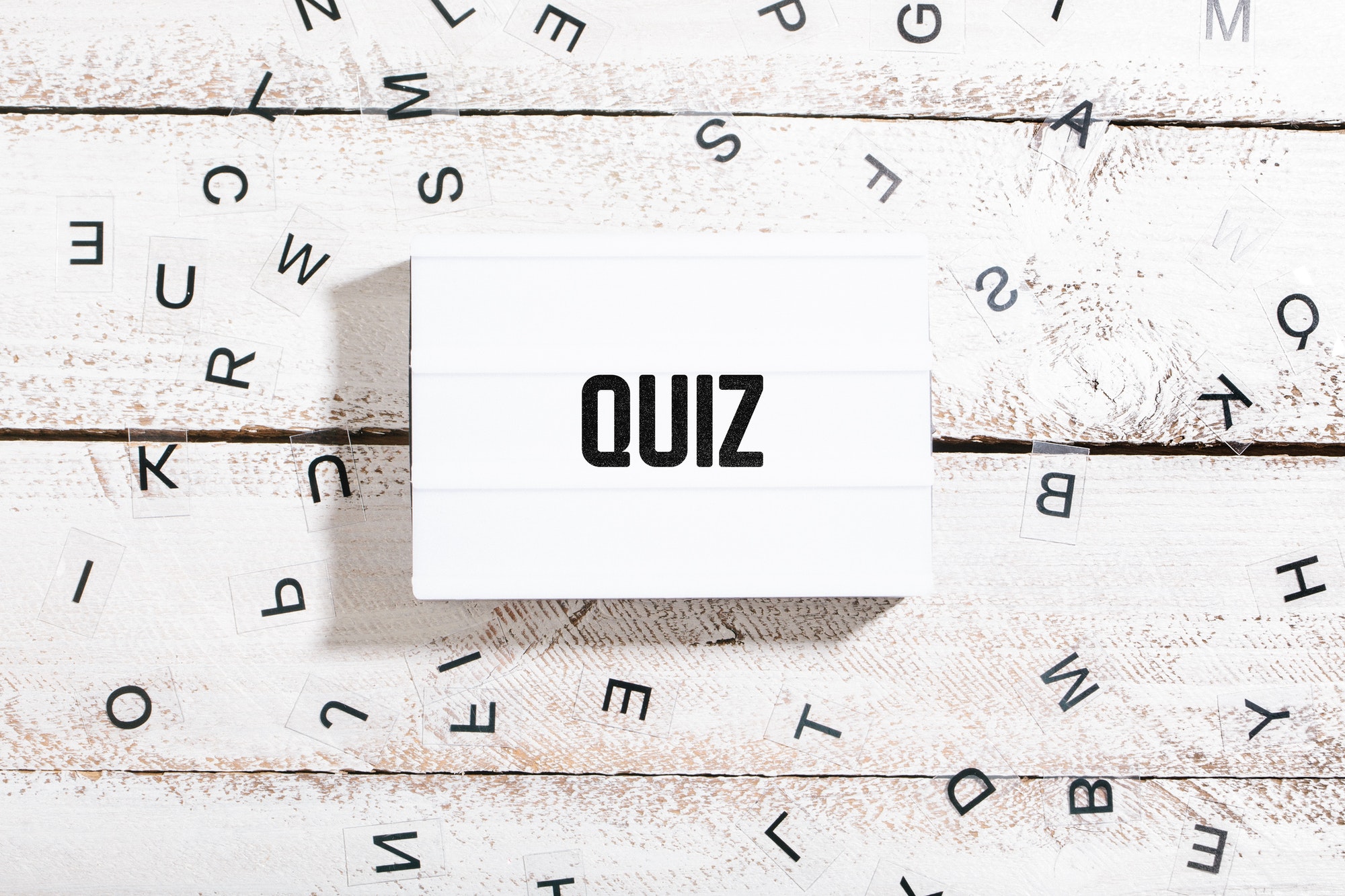 Quiz text on light box with chaos letters on white wood table desk