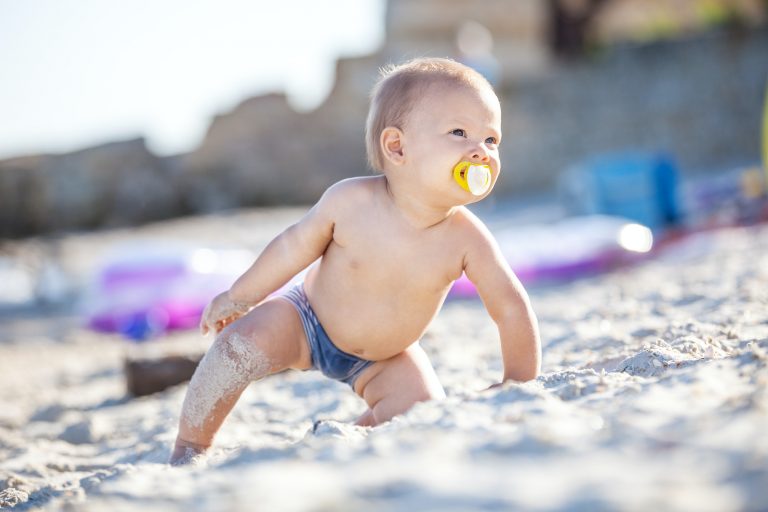 Cute baby boy playing on beach