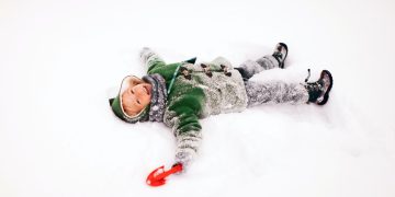 Happy Kid Laying in Snow