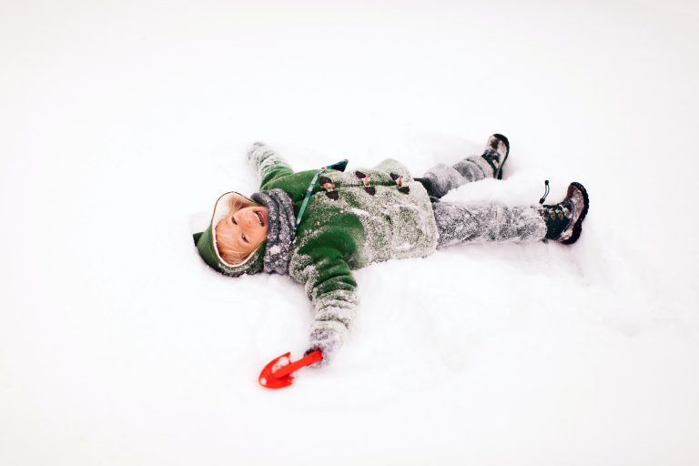 Happy Kid Laying in Snow