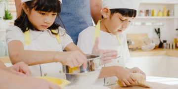 Young Asian Japanese family with preschool kids have cooking for breakfast in modern kitchen home.