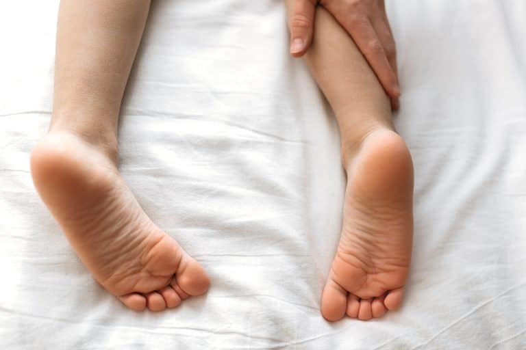 foot massage. children's feet, hands of a masseur